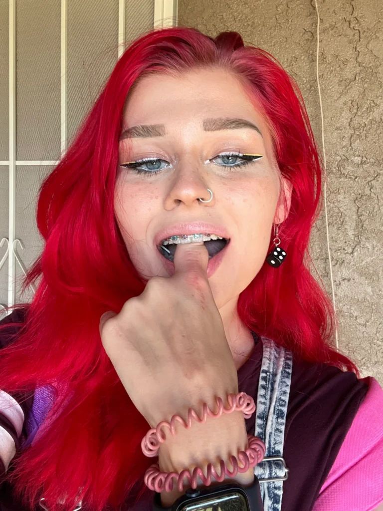 Ariel (@cream.roll) Braces OnlyFans model sexy picture biting her finger with red hair in onlyfans.